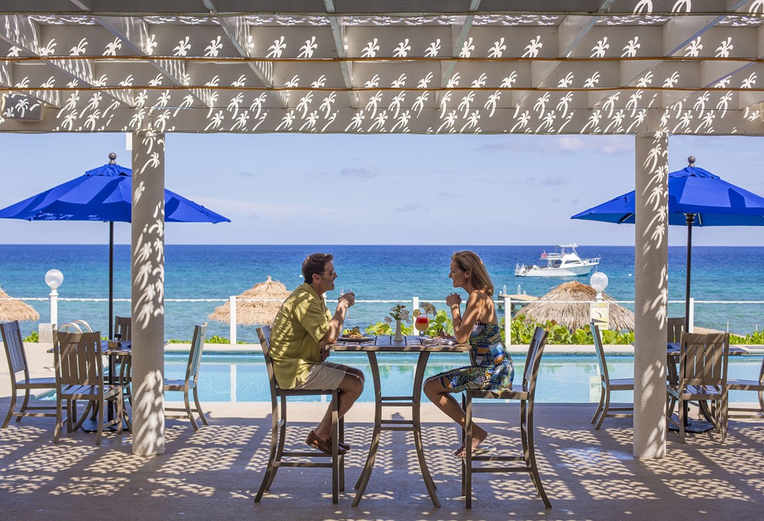 A couple enjoying outdoor dining at a tropical resort