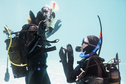 Couple being proposed to under water while diving